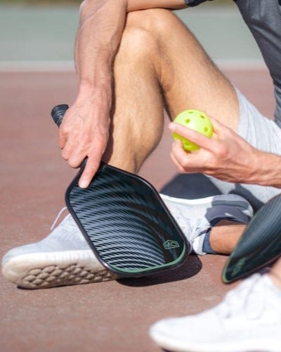 Pickleball players sitting on the court