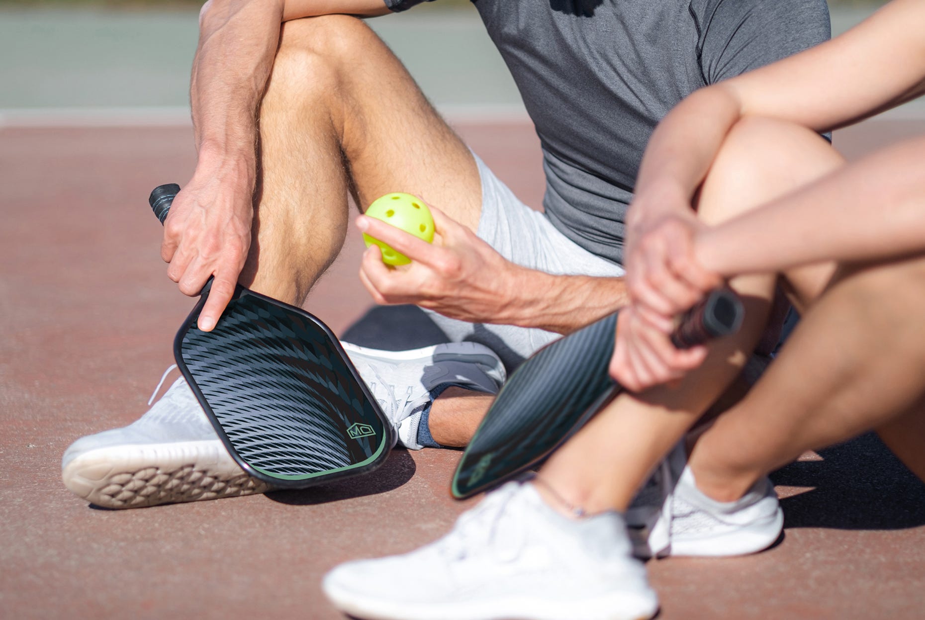 Pickleball Players resting after a hard session on an outdoor court.
